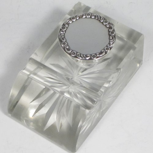 Antique Edwardian sterling silver and hand-cut crystal inkstand, having a rectangular body with chamfered corners, a pen holder groove above a curved front face, plain round silver mount with a hinged lid having an applied floral border, and all sitting on a star-cut flat base. Made by Broadway & Co., of Birmingham in 1904. The dimensions of this fine hand-made silver and crystal inkstand are height 5 cms (2 inches), length 10 cms (4 inches), and width 6.5 cms (2.5 inches).   