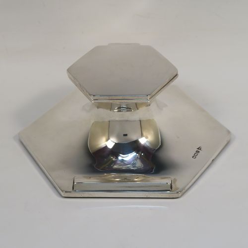 A handsome Antique Sterling Silver large Capstan inkwell, having a plain hexagonal body, with a hinged lid, a glass insert, and a front pen rest. This elegant antique silver inkwell was made by Walker and Hall of Sheffield in 1915. The dimensions of this fine hand-made antique silver capstan style inkwell are height 6 cms (2.3 inches), and width at widest point 15.5 cms (6 inches). Please note that the glass insert is slightly chipped on its upper edge.