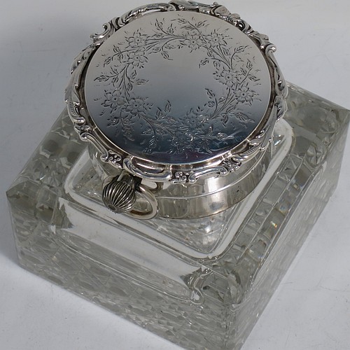 A very handsome and unusual Antique Edwardian Sterling Silver and hand-cut crystal combination inkstand paper weight and clock, having a square body with chamfered upper edges, a plain round mount and a domed hinged lid with hand-engraved floral decoration, the lid enclosing a very fine wind-up clock with black Roman numerals and a white face, all sitting on a flat base with a hand-cut hobnail pattern. Made by Henry Matthews of Birmingham in 1905. The dimensions of this fine antique silver and crystal combination inkstand and clock are height 10 cms (4 inches), and 10 cms (4 inches) square.   