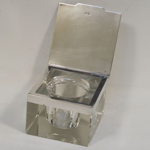 A very stylish Art Deco Sterling Silver and hand-cut crystal inkstand paper weight, having a square body, a plain square mount with a flat-topped hinged lid and engine-turned border, together with a removable glass liner, and all sitting on a flat-cut plain base. This handsome Art Deco inkstand was made by Deakin and Francis of Birmingham in 1933. The dimensions of this fine hand-made silver and crystal inkstand are height 5 cms (2 inches), and 7.5 cms (3 inches) square.   