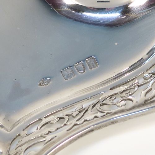 A very pretty and unusual Antique Edwardian Sterling Silver galleried double inkstand, having a triangular body with three hand-pierced scroll-work gallery sides, a removable central single crystal inkwell with a hinged lid, all sitting on a flat base. This beautiful silver inkstand was made by Sibray Hall and Co., of London in 1903. The dimensions of this fine hand-made antique silver  inkstand are width 17 cms (6.75 inches), height 6 cms (2.3 inches), and it weighs approx. 130g (4.2 troy ounces).   