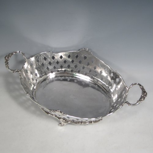 Antique Edwardian sterling silver jardinière, having an oval body with hand-pierced and engraved decoration in a basket-weave style, applied shell and scroll borders, with two cast floral handles, and sitting on four cast scroll feet. Made by Wakely & Wheeler of Chester in 1902. The dimensions of this fine hand-made silver table jardinière are length 35 cms (13.75 inches), width 20 cms (8 inches), height 11.5 cms (4.5 inches), and it weighs approx. 844g (27 troy ounces).