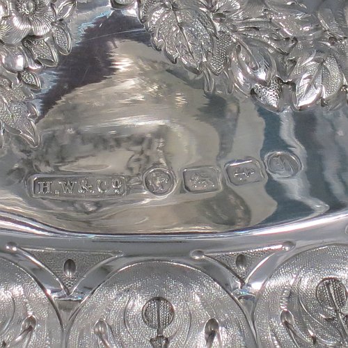 An Antique Victorian Sterling Silver jardinière / epergne, having an oval body with hand-cut crystal bowl, sitting on a cast and hand-chased stand with neoclassical style floral work, all standing on four cast lions-paw feet. Made by Henry Wilkinson of Birmingham in 1882. The dimensions of this fine hand-made antique silver and crystal jardinière / epergne are length 34 cms (13.5 inches), width 25 cms (10 inches), height 30.5 cms (12 inches), and it weighs approx. 1,118g (36 troy ounces).