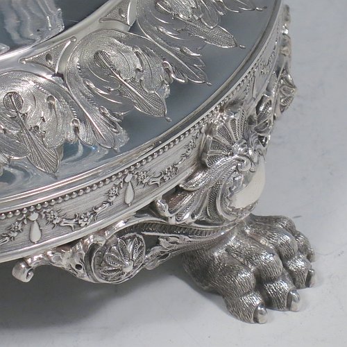 An Antique Victorian Sterling Silver jardinière / epergne, having an oval body with hand-cut crystal bowl, sitting on a cast and hand-chased stand with neoclassical style floral work, all standing on four cast lions-paw feet. Made by Henry Wilkinson of Birmingham in 1882. The dimensions of this fine hand-made antique silver and crystal jardinière / epergne are length 34 cms (13.5 inches), width 25 cms (10 inches), height 30.5 cms (12 inches), and it weighs approx. 1,118g (36 troy ounces).