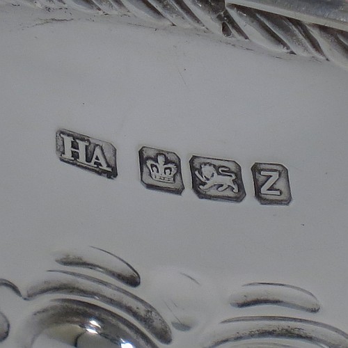 An Antique Victorian Sterling Silver flower Jardiniere, having an oval body, with an applied shaped gadroon border and hand-chased fluted decoration, with vacant round cartouches either side, and sitting on a matching pedestal foot. Made by Henry Atkins of Sheffield in 1892. The dimensions of this fine hand-made antique silver Jardiniere for flowers are length 20 cms (8 inches), width 15 cms (6 inches), height 11 cms (4.25 inches), and it weighs approx. 373g (12 troy ounces). Please note that this piece has its own hand-made to fit silver-plated rose grill.