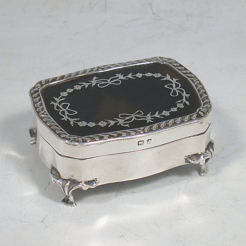 A very pretty Antique Edwardian Sterling Silver and tortoise-shell jewellery box, having a shaped rectangular body, a tortoise-shell hinged lid with in-laid flowers and ribbon bows, an applied gadroon border, a dark blue velvet-lined interior, and sitting on four cast foliate legs. Made by Henry Miller of Birmingham in 1910. The dimensions of this fine hand-made antique silver and tortoise-shell jewelery box are length 7 cms (2.75 inches), width 5.5 cms (2.25 inches), and height 3 cms (1.25 inches).   
