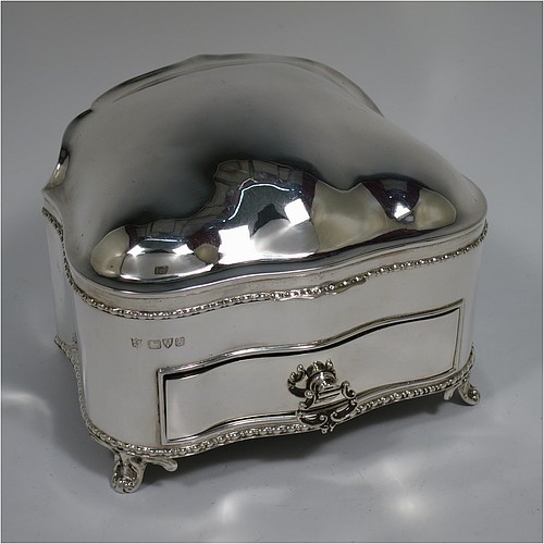 An Antique Edwardian Sterling Silver large jewellery box, having a rectangular shaped casket style body with rounded corners and applied pearl and bead borders, a plain domed hinged lid covering a velvet-lined interior, a pull-out drawer with a cast swing handle, and all sitting on four cast foliate feet. Made by Nathan and Hayes of Chester in 1907. The dimensions of this fine hand-made antique silver jewellery box are length 13.5 cms (5.3 inches), width 11 cms (4.3 inches), and height 11 cms (4.3 inches).   