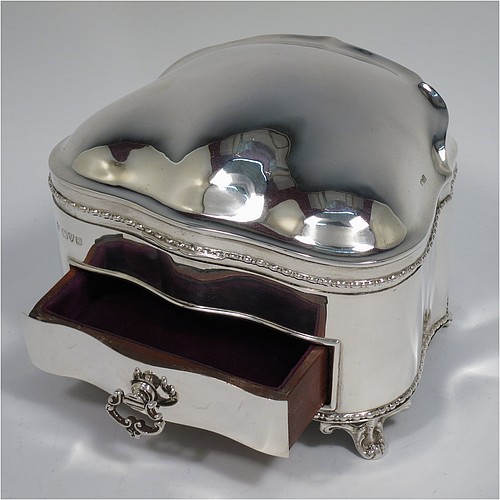 An Antique Edwardian Sterling Silver large jewellery box, having a rectangular shaped casket style body with rounded corners and applied pearl and bead borders, a plain domed hinged lid covering a velvet-lined interior, a pull-out drawer with a cast swing handle, and all sitting on four cast foliate feet. Made by Nathan and Hayes of Chester in 1907. The dimensions of this fine hand-made antique silver jewellery box are length 13.5 cms (5.3 inches), width 11 cms (4.3 inches), and height 11 cms (4.3 inches).