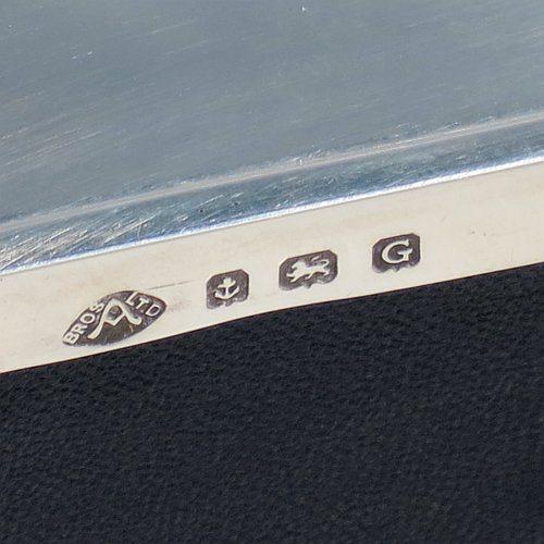 A Sterling Silver Art Deco style jewellery box, having an elongated octagonal body with plain panelled sides, a hinged lid with an applied bright-cut border and engine-turned decoration, a blue velvet-lined and gold-gilt interior, and sitting on four elegant cabriolet legs. Made by Alexander Clarke & Co., of Birmingham in 1931. The dimensions of this fine hand-made silver jewelery box are length 11.5 cms (4.5 inches), width 6.5 cms (2.5 inches), and height 5 cms (2 inches).