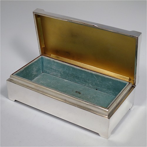 A large Art Deco Sterling Silver jewelery box, having a very plain rectangular body sitting on four corner feet, with angular hand-engraved top corners, a slightly concave and hinged lid with thumb-piece and gold-gilt interior, and the base with a light blue velvet lining. Made by Percy James Finch of Birmingham in 1930. The dimensions of this fine hand-made silver jewellery table box are height 5 cms (2 inches), length 18 cms (7 inches), and width 9 cms (3.7 inches).