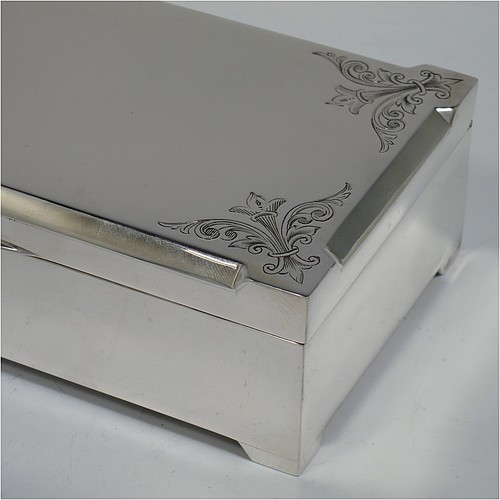 A large Art Deco Sterling Silver jewelery box, having a very plain rectangular body sitting on four corner feet, with angular hand-engraved top corners, a slightly concave and hinged lid with thumb-piece and gold-gilt interior, and the base with a light blue velvet lining. Made by Percy James Finch of Birmingham in 1930. The dimensions of this fine hand-made silver jewellery table box are height 5 cms (2 inches), length 18 cms (7 inches), and width 9 cms (3.7 inches).