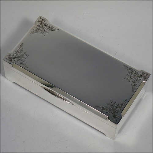 A large Art Deco Sterling Silver jewelery box, having a very plain rectangular body sitting on four corner feet, with angular hand-engraved top corners, a slightly concave and hinged lid with thumb-piece and gold-gilt interior, and the base with a light blue velvet lining. Made by Percy James Finch of Birmingham in 1930. The dimensions of this fine hand-made silver jewellery table box are height 5 cms (2 inches), length 18 cms (7 inches), and width 9 cms (3.7 inches).