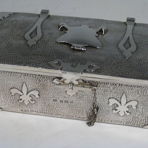 Antique Edwardian sterling silver Arts and Crafts style casket jewelery box, having a hand-hammered rectangular body, with cut-card work in a Medieval style, a hinged lock and chain, and a velvet lined interior. Made by J. Gilbert of Birmingham in 1906. Height 6.5 cms (2.5 inches), length 18.5 cms (7.25 inches), depth 10 cms (4 inches). Weight approx. 400g (13 troy ounces).