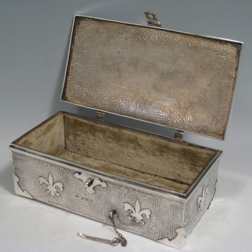 Antique Edwardian sterling silver Arts and Crafts style casket jewelery box, having a hand-hammered rectangular body, with cut-card work in a Medieval style, a hinged lock and chain, and a velvet lined interior. Made by J. Gilbert of Birmingham in 1906. Height 6.5 cms (2.5 inches), length 18.5 cms (7.25 inches), depth 10 cms (4 inches). Weight approx. 400g (13 troy ounces).