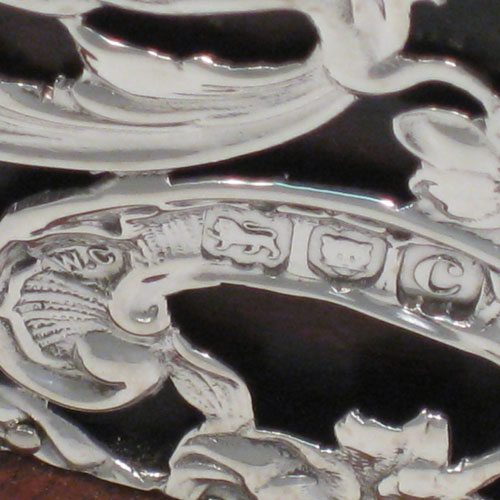 Antique Victorian sterling silver jewellery box, having a hinged lid, a satin-lined interior, a rectangular wooden body with hand-pierced silver panels which are pinned to the wood, with cherubs, birds, faces, and styalised floral decoration. Made by William Comyns of London in 1898. Length 31 cms (12.25 inches), height 8.5 cms (3.3 inches), width 21 cms (8.25 inches).