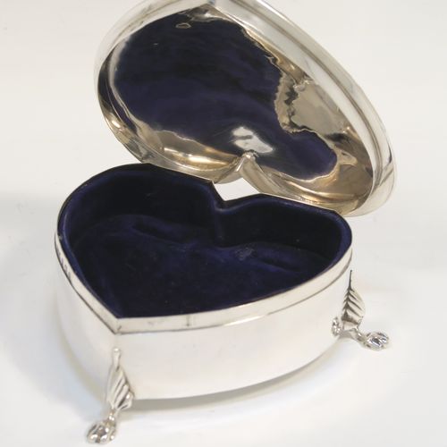 A pretty Antique Edwardian Sterling Silver jewellery box, having a plain heart-shaped body with straight sides, a hinged lid with an applied ribbon and reed border, and dark-blue velvet-lined interior, and all sitting on three cast lions-paw feet. This beautiful heart-shaped silver jewelery box was made by T. H. Hazlewood of Birmingham in 1907. The dimensions of this fine hand-made antique silver jewelery box are length 10 cms (4 inches), width 11 cms (4.3 inches), and height 4 cms (1.5 inches).