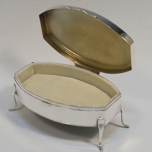 A very elegant Antique Sterling Silver jewelery box, having a plain oval-shaped body with straight sides and squared-off ends, a slightly domed hinged lid with a reeded border, a gold gilt and cream velvet-lined interior, and all sitting on four plain feet. This handsome silver jewellery box was made by Edward Souter Barnsley of Birmingham in 1919. The dimensions of this fine hand-made antique silver jewellery box are width 13cms (5 inches), depth 9cms (3.5 inches), and height 6 cms (2.3 inches)
