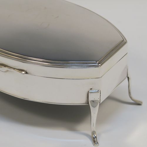 A very elegant Antique Sterling Silver jewelery box, having a plain oval-shaped body with straight sides and squared-off ends, a slightly domed hinged lid with a reeded border, a gold gilt and cream velvet-lined interior, and all sitting on four plain feet. This handsome silver jewellery box was made by Edward Souter Barnsley of Birmingham in 1919. The dimensions of this fine hand-made antique silver jewellery box are width 13cms (5 inches), depth 9cms (3.5 inches), and height 6 cms (2.3 inches)