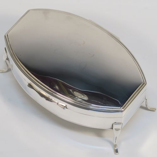 A very elegant Antique Sterling Silver jewelery box, having a plain oval-shaped body with straight sides and squared-off ends, a slightly domed hinged lid with a reeded border, a gold gilt and cream velvet-lined interior, and all sitting on four plain feet. This handsome silver jewellery box was made by Edward Souter Barnsley of Birmingham in 1919. The dimensions of this fine hand-made antique silver jewellery box are width 13cms (5 inches), depth 9cms (3.5 inches), and height 6 cms (2.3 inches)