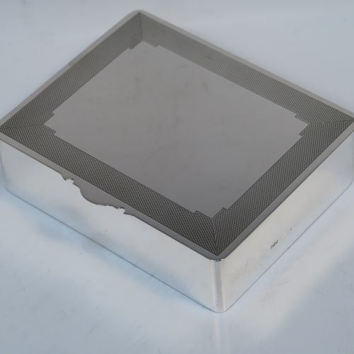 A very handsome Art Deco Sterling Silver jewelery box, having a very plain rectangular body, a hinged lid with engine-turned top border and thumb-piece, a maroon velvet-lined interior, and sitting on a flat base. This elegant and stylish jewellery box was made by Mappin and Webb of Birmingham in 1937. The dimensions of this fine hand-made silver jewellery table box are height 3.25 cms (1.25 inches), length 12 cms (4.75 inches), and width 9.5 cms (3.75 inches).