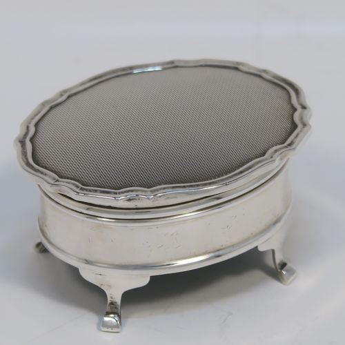 A small but elegant Sterling Silver jewelery box, having a plain oval-shaped body with straight sides, a slightly domed hinged lid with an applied Chippendale border and engine-turned engraved decoration, a gold gilt and red velvet-lined interior, and all sitting on four flanged feet. This beautiful silver jewellery box was made by the Adie Brothers of Birmingham in 1962. The dimensions of this fine hand-made antique silver jewellery box are length 7.5 cms (3 inches), width 6 cms (2.3 inches), and height 4 cms (1.5 inches)   