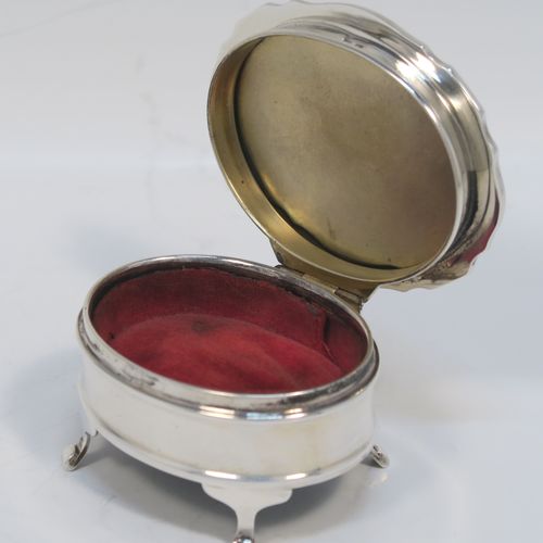 A small but elegant Sterling Silver jewelery box, having a plain oval-shaped body with straight sides, a slightly domed hinged lid with an applied Chippendale border and engine-turned engraved decoration, a gold gilt and red velvet-lined interior, and all sitting on four flanged feet. This beautiful silver jewellery box was made by the Adie Brothers of Birmingham in 1962. The dimensions of this fine hand-made antique silver jewellery box are length 7.5 cms (3 inches), width 6 cms (2.3 inches), and height 4 cms (1.5 inches)