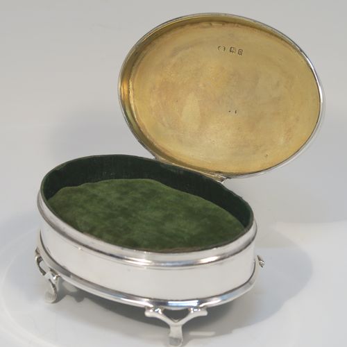 A very elegant Antique Sterling Silver jewelery box, having a plain oval-shaped body with straight sides, a slightly domed hinged lid with an applied pear and bead top border, a gold gilt and green velvet-lined interior, and all sitting on four flanged feet. This handsome silver jewellery box was made by Charles Edwards of London in 1918. The dimensions of this fine hand-made antique silver jewellery box are width 9 cms (3.5 inches), depth 6.5 cms (2.5 inches), and height 4.5 cms (1.75 inches)