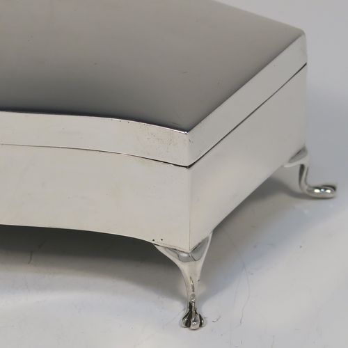 A very handsome Antique Sterling Silver jewelery box, having a dressing table style plain rectangular bow-fronted body, a plain and slightly domed hinged, a gold gilt and dark blue satin-lined interior, and all sitting on four cabriolet feet. This elegant antique silver jewellery box was made by Deakin and Francis of Birmingham in 1919. The dimensions of this fine hand-made antique silver jewellery box are width 13 cms (5 inches), depth 8 cms (3 inches), and height 5 cms (2 inches)