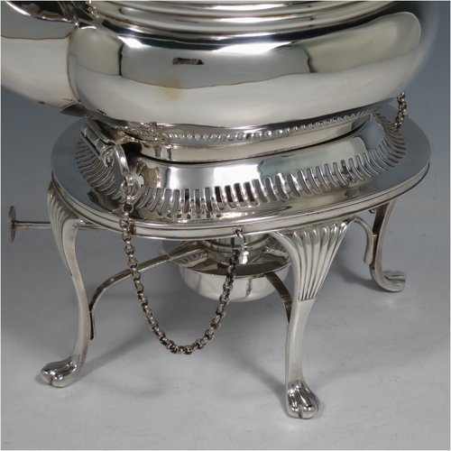 An Antique Edwardian Sterling Silver tea kettle on a burner stand, having a Georgian style rectangular baluster body, with a hinged domed lid, an insulated wooden handle and finial, and sitting on an original burner stand with a pierced border and four fluted feet. Made by Mappin & Webb of Sheffield in 1903. The dimensions of this fine hand-made antique silver kettle are length 23 cms (9 inches), height 33 cms (13 inches), width 15 cms (6 inches), and the total weight is approx. 1,145g (37 troy ounces).