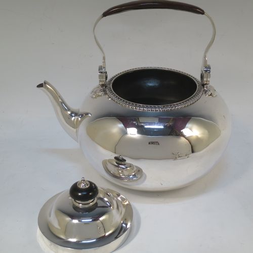 A very handsome Antique Victorian Sterling Silver tea kettle on a burner stand, having a plain round bellied body with an applied gadroon border, a lift-off lid with wooden finial, a leather covered hinged handle, and sitting on an original burner stand with removable central wick and three cast shell feet. Made by Joshua Vander of London in 1893. The dimensions of this fine hand-made antique silver kettle are length 21 cms (8.25 inches), height 27.5 cms (10.75 inches), width 18 cms (7 inches), and the total weight is approx. 770g (24.8 troy ounces).