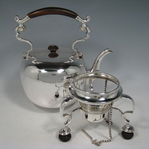 Antique Victorian sterling silver kettle on a burner stand in an early George I style, having a very plain round body, with wooden insulated scroll handle, a plain spout, a hinged lid with invisible hinge and wooden finial, and all sitting on a frame with original burner and securing pins with chains. All made by Thomas and Walter Slater of London in 1895. The dimensions of this fine hand-made silver kettle are height 32 cms (12.5 inches), length 21 cms (8.25 inches), and it weighs approx. 1,178g (38 troy ounces).