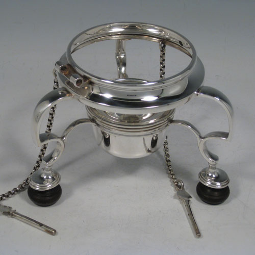 Antique Victorian sterling silver kettle on a burner stand in an early George I style, having a very plain round body, with wooden insulated scroll handle, a plain spout, a hinged lid with invisible hinge and wooden finial, and all sitting on a frame with original burner and securing pins with chains. All made by Thomas and Walter Slater of London in 1895. The dimensions of this fine hand-made silver kettle are height 32 cms (12.5 inches), length 21 cms (8.25 inches), and it weighs approx. 1,178g (38 troy ounces).