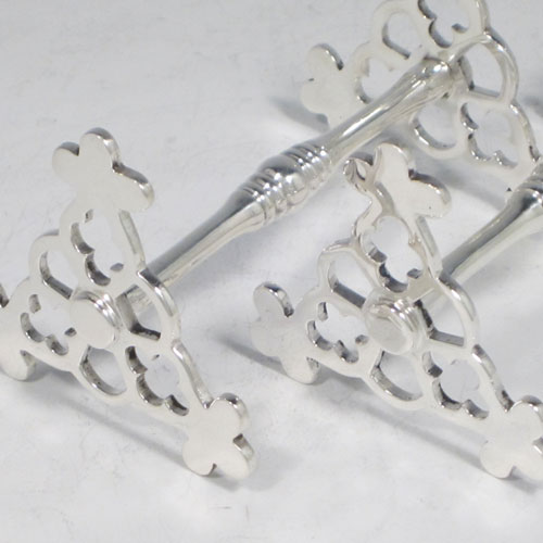 Antique Edwardian sterling silver pair of knife rests, with hand-pierced Gothic style rest ends, and reeded central struts. Made by Goldsmiths and Silversmiths of London in 1905. The dimensions of this fine hand-made pair of silver knife rests are length 8.5 cms (3.3 inches), height 5 cms (2 inches), and they weigh a total of approx. 128g (4 troy ounces).
