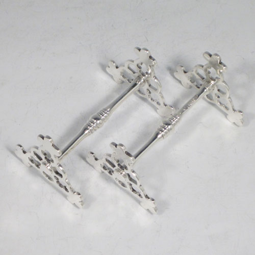 Antique Edwardian sterling silver pair of knife rests, with hand-pierced Gothic style rest ends, and reeded central struts. Made by Goldsmiths and Silversmiths of London in 1905. The dimensions of this fine hand-made pair of silver knife rests are length 8.5 cms (3.3 inches), height 5 cms (2 inches), and they weigh a total of approx. 128g (4 troy ounces).