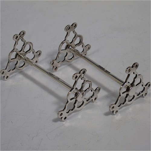A very pretty Antique Sterling Silver pair of knife rests, with hand-pierced and scroll style rest ends, and plain round central struts. Made by James Dixon Sheffield in 1913. The dimensions of this fine hand-made pair of antique silver knife rests are length 7 cms (2.75 inches), height 4 cms (1.5 inches), and they weigh a total of approx. 47g (1.5 troy ounces).