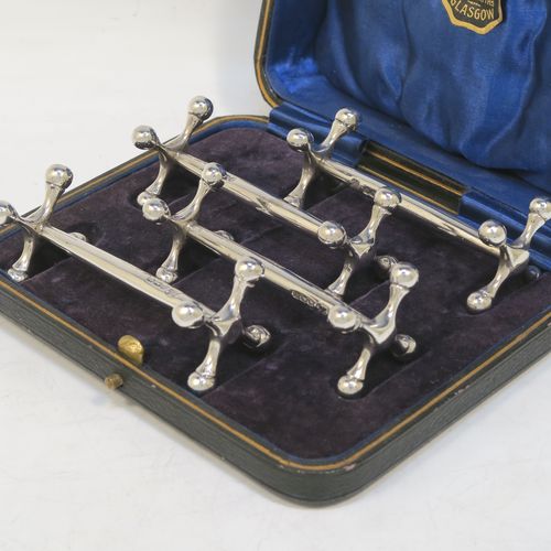 A handsome Sterling Silver set of four knife rests, with traditional cast Jack-style rest ends, and plain round central struts, all in their original dark blue satin and velvet-lined presentation box. Made by Martin Hall and Co., of Sheffield in 1922. The dimensions of this fine hand-made set of four silver knife rests are length 8.5 cms (3.3 inches), height 3 cms (1.25 inches), and they weigh a total of approx. 224g (7.2 troy ounces).