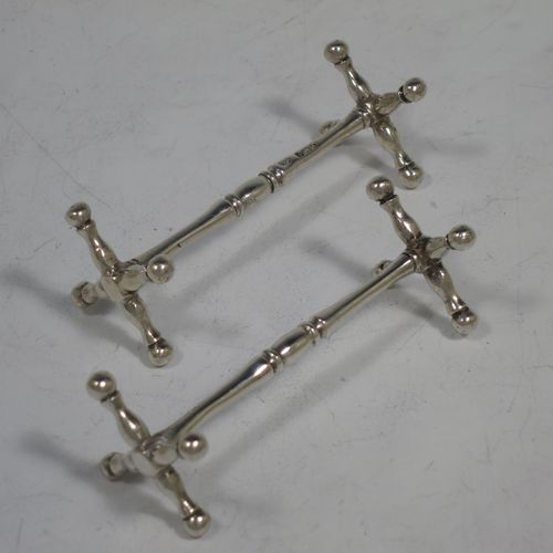 A handsome Sterling Silver pair of knife rests, with traditional cast Jack-style rest ends, and round central struts with reeded decoration. Made by William Hutton & Sons of Sheffield in 1922. The dimensions of this fine hand-made pair of silver knife rests are length 7 cms (2.75 inches), height 2.5 cms (1 inch), and they weigh a total of approx. 43g (1.4 troy ounces).