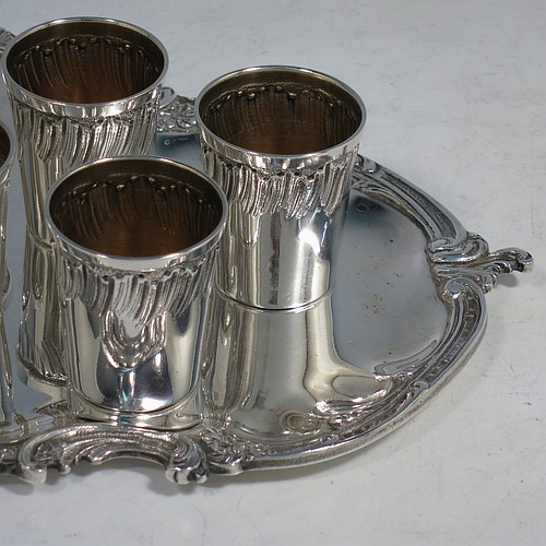 An Antique Victorian French First Quality Standard (950 std) sterling silver set of six liqueor tots / measures and original serving salver, the tots having round straight-sided bodies with gold-gilt interiors and hand-chased swirl-fluted upper borders, the salver with a plain ground and an applied cast foliate border. Made in France in ca. 1890. The dimensions of this fine hand-made antique silver liqueur set are height of tots 4 cms (1.5 inches), length of serving tray 20 cms (8 inches), and the total weight is approx. 285g (9.2 troy ounces).