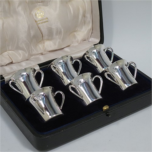 An Antique Edwardian Sterling Silver set of six liqueor tots or measures, round straight-sided bodies with three loop side-handles, all in their original cream satin and dark blue velvet-lined presentation box. Made by Elkington and Co., of Birmingham in 1909. The dimensions of this fine hand-made antique silver liqueur set are height 4 cms (1.5 inches), diameter 4 cms (1.5 inches), and the total weight is approx. 195g (6.3 troy ounces).    