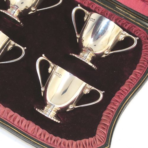 A very handsome Antique Edwardian Sterling Silver set of six liqueur tots or measures, having round trophy style bodies, with two loop side-handles, and sitting on pedestal feet, all in their original maroon satin and velvet-lined presentation box. This beautiful antique set of silver tots were made by Whakeley and Wheeler of London in 1904. The dimensions of this fine hand-made antique silver liqueur set are height 4 cms (1.5 inches), diameter 3.5 cms (1.3 inches), and the total weight is approx. 223g (7.2 troy ounces).