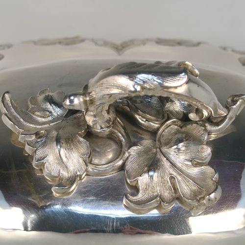 A beautiful Antique Victorian Silver Plated meat cover dome, having an oval domed body with hand-chased floral decoration surrounding two vacant cartouches on both sides, a cast floral loop handle, and an applied bead-edged bottom border. This stunning silver-plated meat cover was made in ca. 1870. The dimensions of this fine hand-made antique silver-plated meat cover dome are length 47 cm (18.5 inches), width 35.5 cms (14 inches), and height 28 cms (11 inches).   