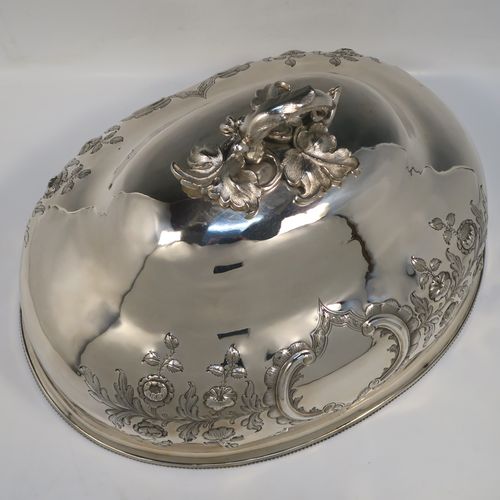 A beautiful Antique Victorian Silver Plated meat cover dome, having an oval domed body with hand-chased floral decoration surrounding two vacant cartouches on both sides, a cast floral loop handle, and an applied bead-edged bottom border. This stunning silver-plated meat cover was made in ca. 1870. The dimensions of this fine hand-made antique silver-plated meat cover dome are length 47 cm (18.5 inches), width 35.5 cms (14 inches), and height 28 cms (11 inches).   