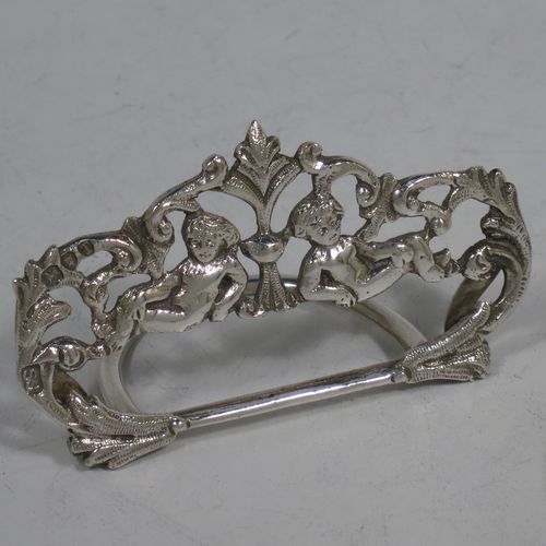 A very pretty Antique Victorian Sterling Silver set of four place card holders, having cast bodies with reclining cherubs over scroll and floral decoration, and sitting on half-circle wire-work bases. Made by Samuel Jacob of London in 1894. The dimensions of this fine set of antique silver place card holders are width 7 cms (2.75 inches), height 4 cms (1.5 inches), depth 3 cms (1.25 inches), and they weigh a total of approx. 106g (3.4 troy ounces).