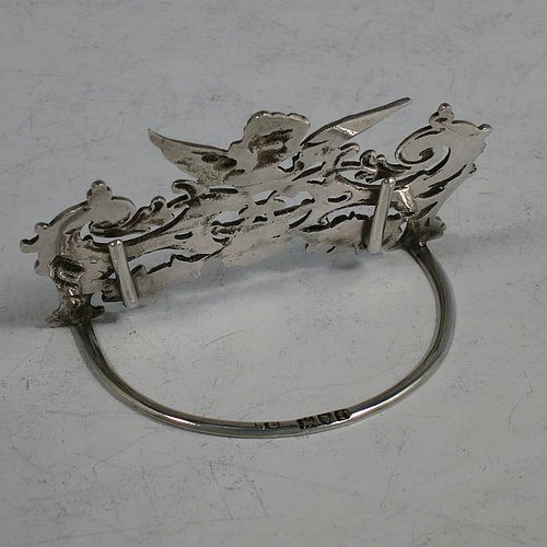 An Antique Sterling Silver set of four place card holders, having cast bodies with winged seraphims over scroll and floral decoration, and sitting on half-circle wire-work bases. Made by Stuart Clifford of London in 1904. The dimensions of this fine set of antique silver place card holders are width 7.5 cms (3 inches), height 5 cms (2 inches), depth 4 cms (1.5 inches), and they weigh a total of approx. 101g (3.3 troy ounces).