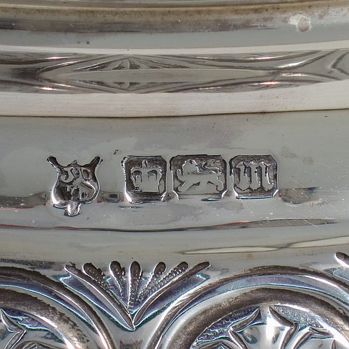 An Antique Edwardian Sterling Silver mirror plateau, having a round body with hand-chased floral decoration, a plain reeded border surrounding the mirror, all sitting on three cast foliate and lions-paw feet, and an original oak base underneath. Made by the Deakin Brothers of Sheffield in 1904. The dimensions of this fine hand-made antique silver mirror plateau are diameter 38 cms (15 inches), and height 9 cms (3.5 inches).