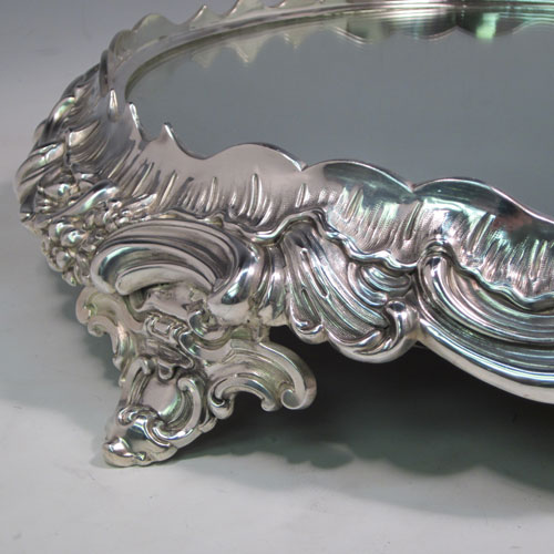 An elegant Antique Victorian silver-plated mirror plateau, having a round body, with hand-chased floral decoration, and sitting on four foliate feet. This beautiful antique silver plated mirror plateau was made in ca. 1880. The dimensions of this fine hand-made silver-plated mirror plateau are diameter 43 cms (17 inches), and height 9 cms (3.5 inches).