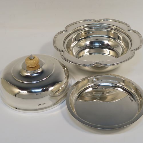 An elegant Sterling Silver muffin dish, having a round body with an applied and shaped reeded petal border, a domed lift-off lid with a bone finial, an original internal liner, and all sitting on a flat base. This beautiful silver caviar or muffin dish was made by Mappin and Webb of Sheffield in 1926. The dimensions of this fine hand-made silver muffin or caviar dish are diameter 18 cms (7 inches), height 10 cms (4 inches), and it weighs approx. 550g (17.7 troy ounces).