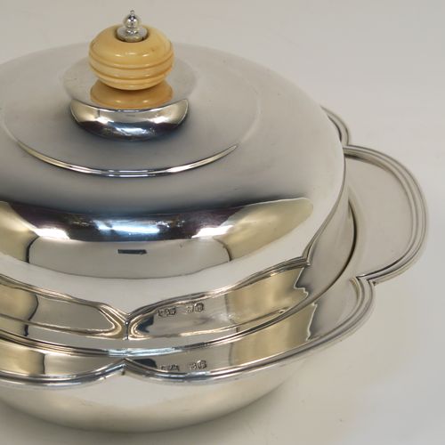 An elegant Sterling Silver muffin dish, having a round body with an applied and shaped reeded petal border, a domed lift-off lid with a bone finial, an original internal liner, and all sitting on a flat base. This beautiful silver caviar or muffin dish was made by Mappin and Webb of Sheffield in 1926. The dimensions of this fine hand-made silver muffin or caviar dish are diameter 18 cms (7 inches), height 10 cms (4 inches), and it weighs approx. 550g (17.7 troy ounces).