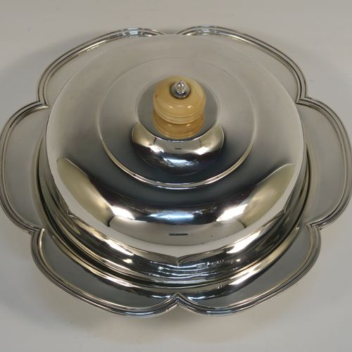 An elegant Sterling Silver muffin dish, having a round body with an applied and shaped reeded petal border, a domed lift-off lid with a bone finial, an original internal liner, and all sitting on a flat base. This beautiful silver caviar or muffin dish was made by Mappin and Webb of Sheffield in 1926. The dimensions of this fine hand-made silver muffin or caviar dish are diameter 18 cms (7 inches), height 10 cms (4 inches), and it weighs approx. 550g (17.7 troy ounces).