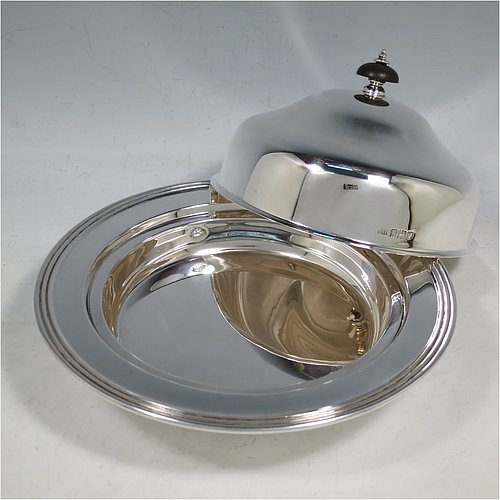 An Antique Sterling Silver muffin dish, having a plain round body with reeded border, a domed lift-off lid with wooden finial, an interior lift-out liner with space underneath for hot water or crushed ice, and sitting on a flat base. Made by Harrison Brothers & Howson of in 1912. The dimensions of this fine hand-made antique silver muffin dish are diameter 18.5 cms (7.3 inches), height 11.5 cms (4.5 inches), and it weighs approx. 486g (15.7 troy ounces).